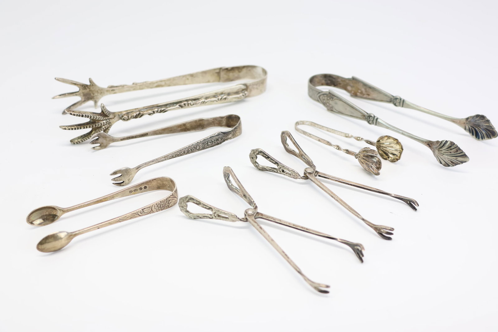Group of Assorted Tongs: Group of Assorted Tongs Group of Assorted Tongs comprising of P. Lopez Mexican sterling claw tongs, Wallace sterling sugar tongs, and a pair of English silver sugar tongs. Together with a pair of Al