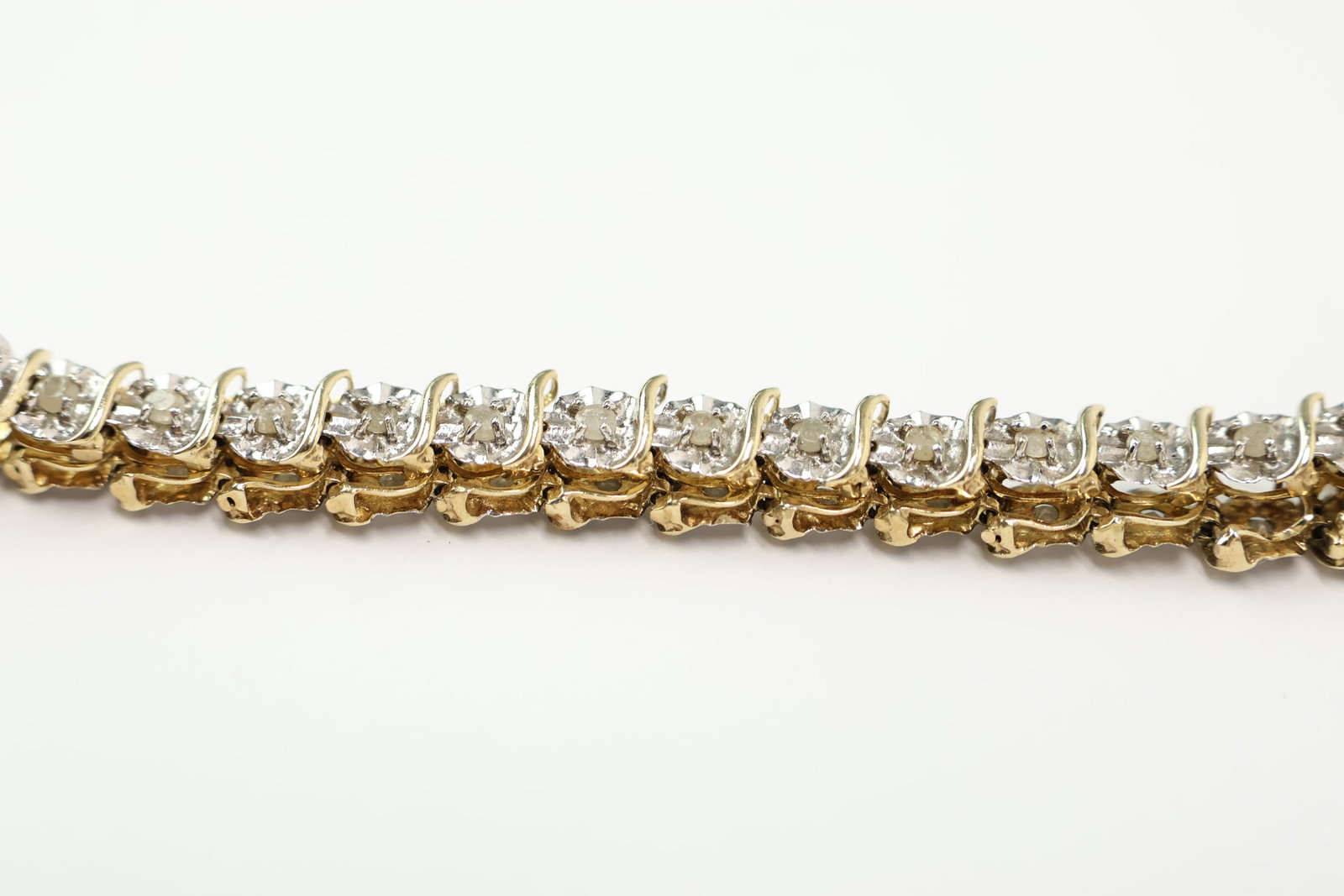 10K Yellow & White Gold Diamond Bracelet: 10K Yellow & White Gold Diamond Bracelet 10K Yellow & White Gold Diamond Bracelet. Having 35 inset rough cut diamonds that are approximately .03 to .05 carts per. used condition; measures