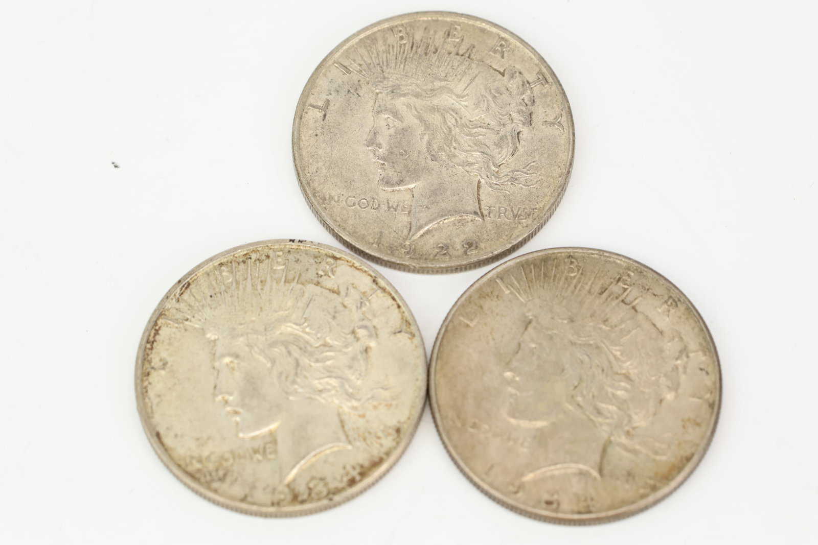 Three Silver Peace Dollar Coins: Three Silver Peace Dollar Coins Three Silver Peace Dollar Coins. Comprising two 1934 and one 1922. Used condition, wear, worn.