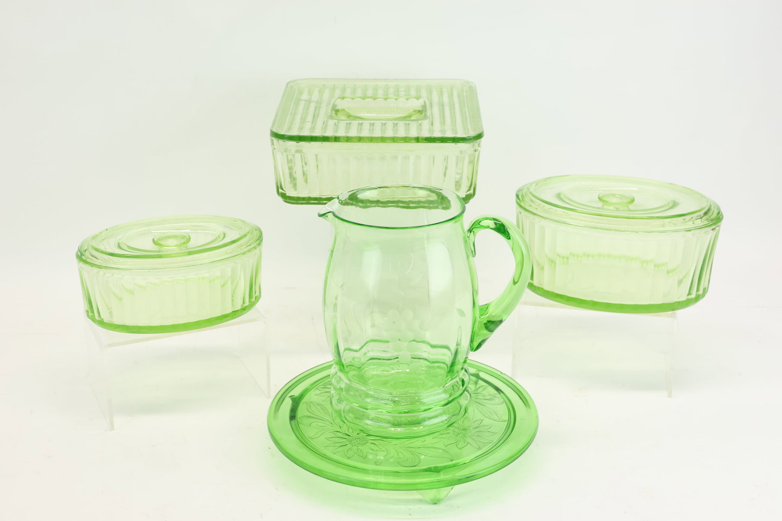 Group of Assorted Green Uranium Glass Table Articles: Group of Assorted Green Uranium Glass Table Articles Group of Assorted Green Uranium Glass Table Articles, including, covered dishes, pitcher, and cake plate; Used condition, wear, worn.