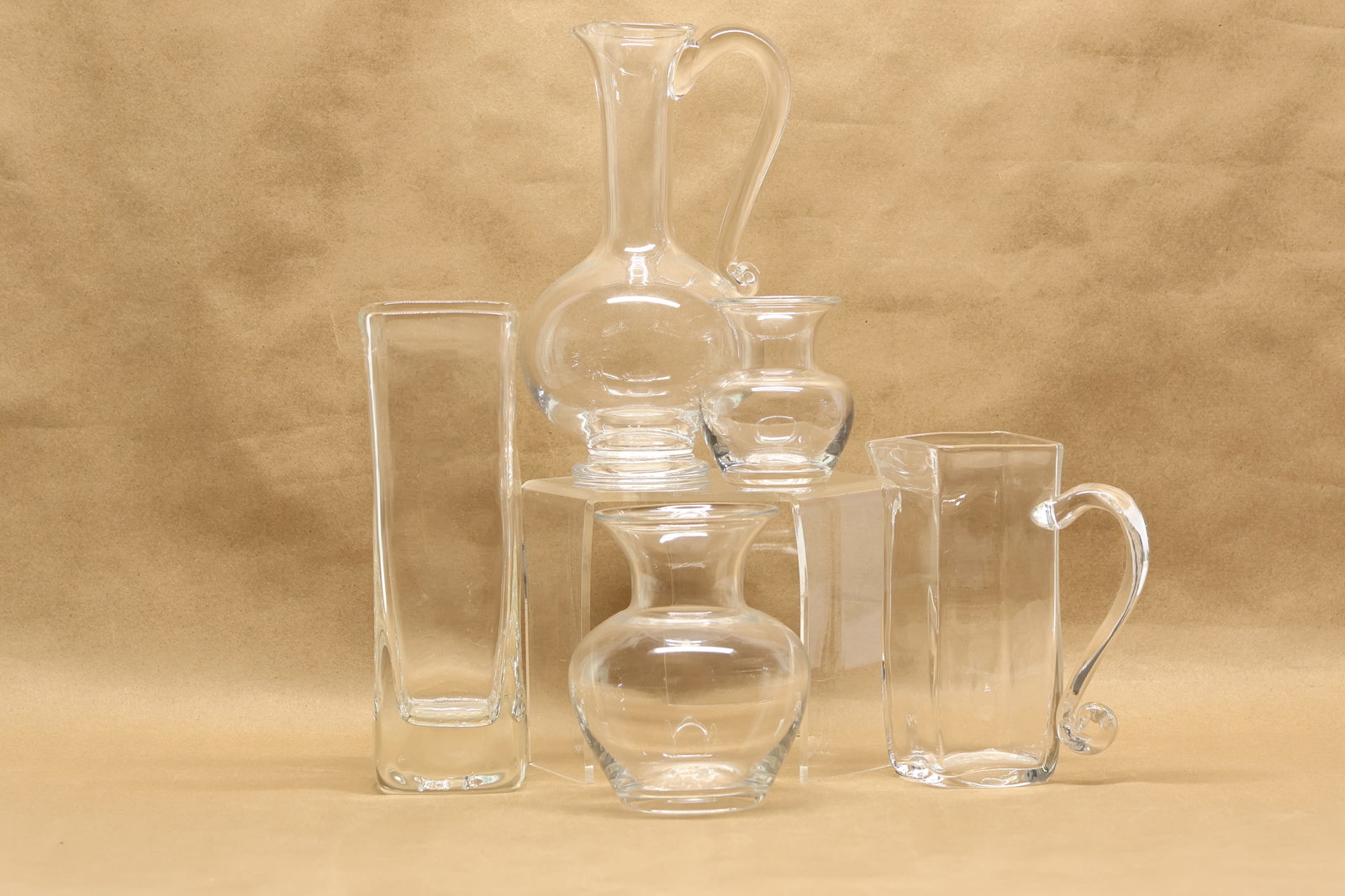 Five Simon Pearce Glass Table Articles: Five Simon Pearce Glass Table Articles Five Simon Pearce Glass Table Articles, comprising, two pitchers and three vases. Used condition, wear, worn. Tallest: 10 1/4"h x 3 1/2"w x 3 1/2"d