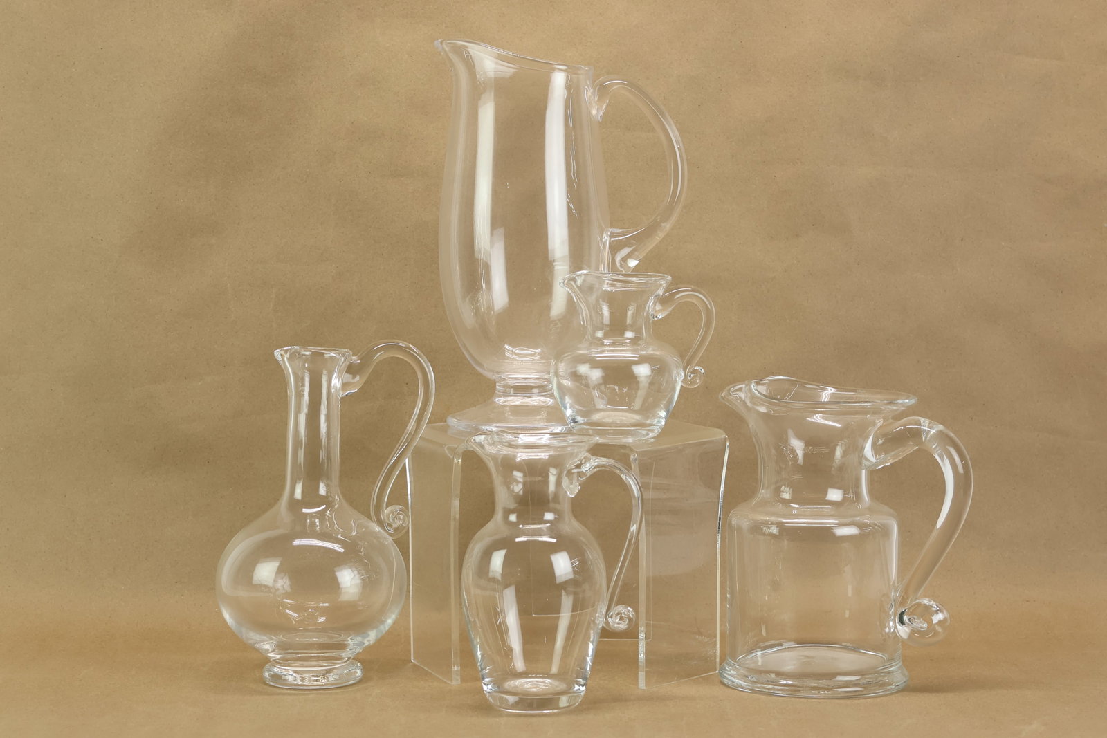 Five Simon Pearce Glass Pitchers: Five Simon Pearce Glass Pitchers Five Simon Pearce Glass Pitchers. Used condition, wear, worn. Tallest: 10 1/2"h x 7 1/4"w x 3 1/2"d