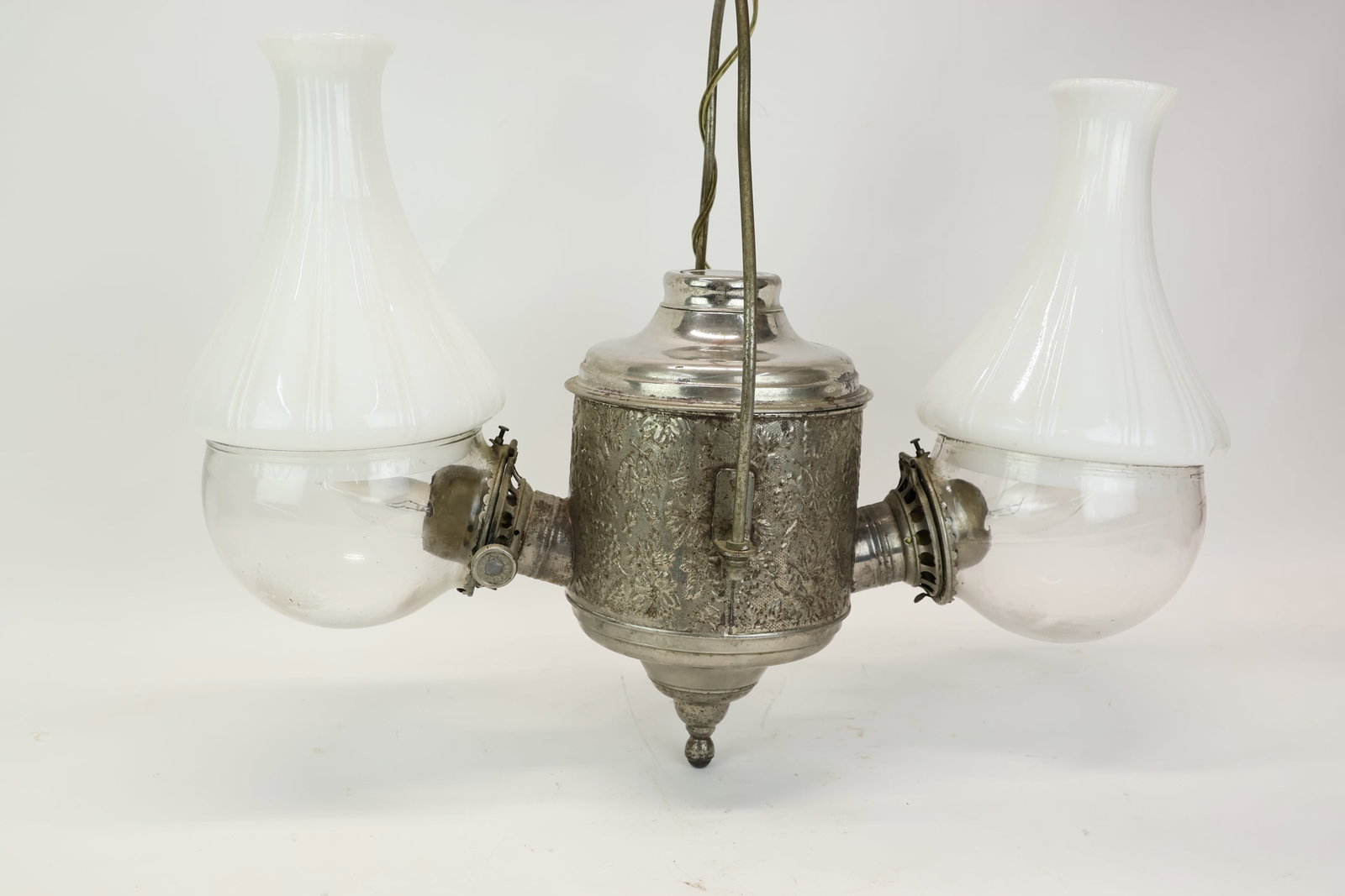 Antique Double Arm Angle Lamp: Antique Double Arm Angle Lamp Antique Double Arm Angle Lamp. Double burner fluid hanging lamp converted to electric with a floral embossed metal body and milk glass lamp shades. Clear glass globes
