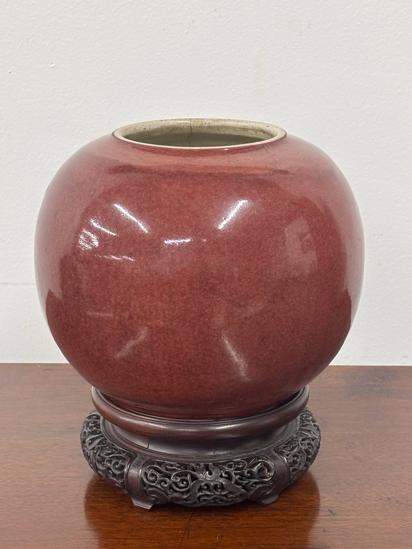 Chinese Sang de Boeuf Porcelain Jar: Chinese Sang de Boeuf Porcelain Jar Chinese Sang de Boeuf Porcelain Jar, with hardwood stand. Crack on side, used condition, wear, worn. Without stand: 7 1/4"h x 8 1/2"dia.