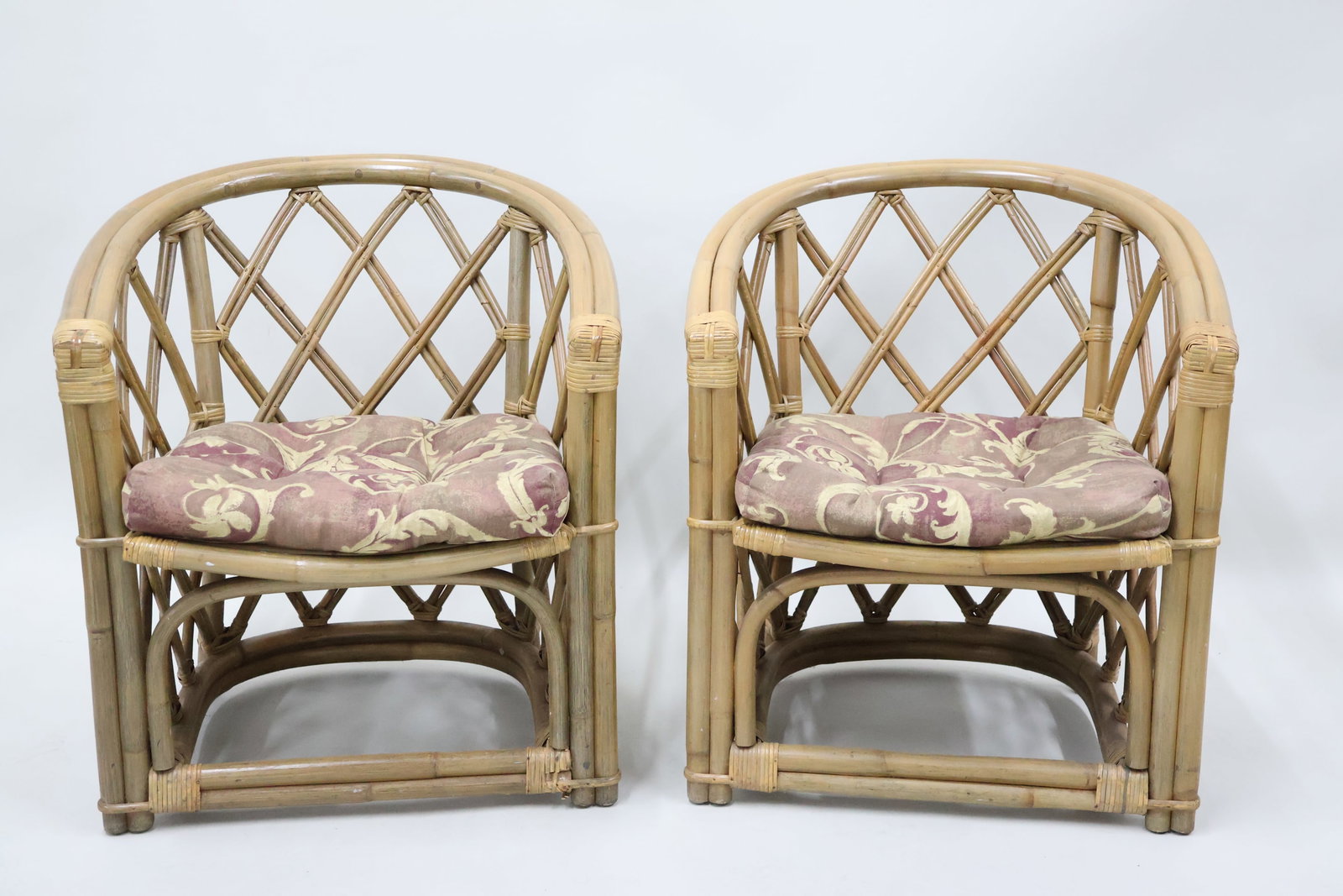 Pair of Mid-Century Rattan Barrel Chairs with Cushions: Pair of Mid-Century Rattan Barrel Chairs with Cushions Pair of Mid-Century Rattan Barrel Chairs with Tufted Removable Cushions in floral fabric; used condition, wear/worn, fading to cushions, some