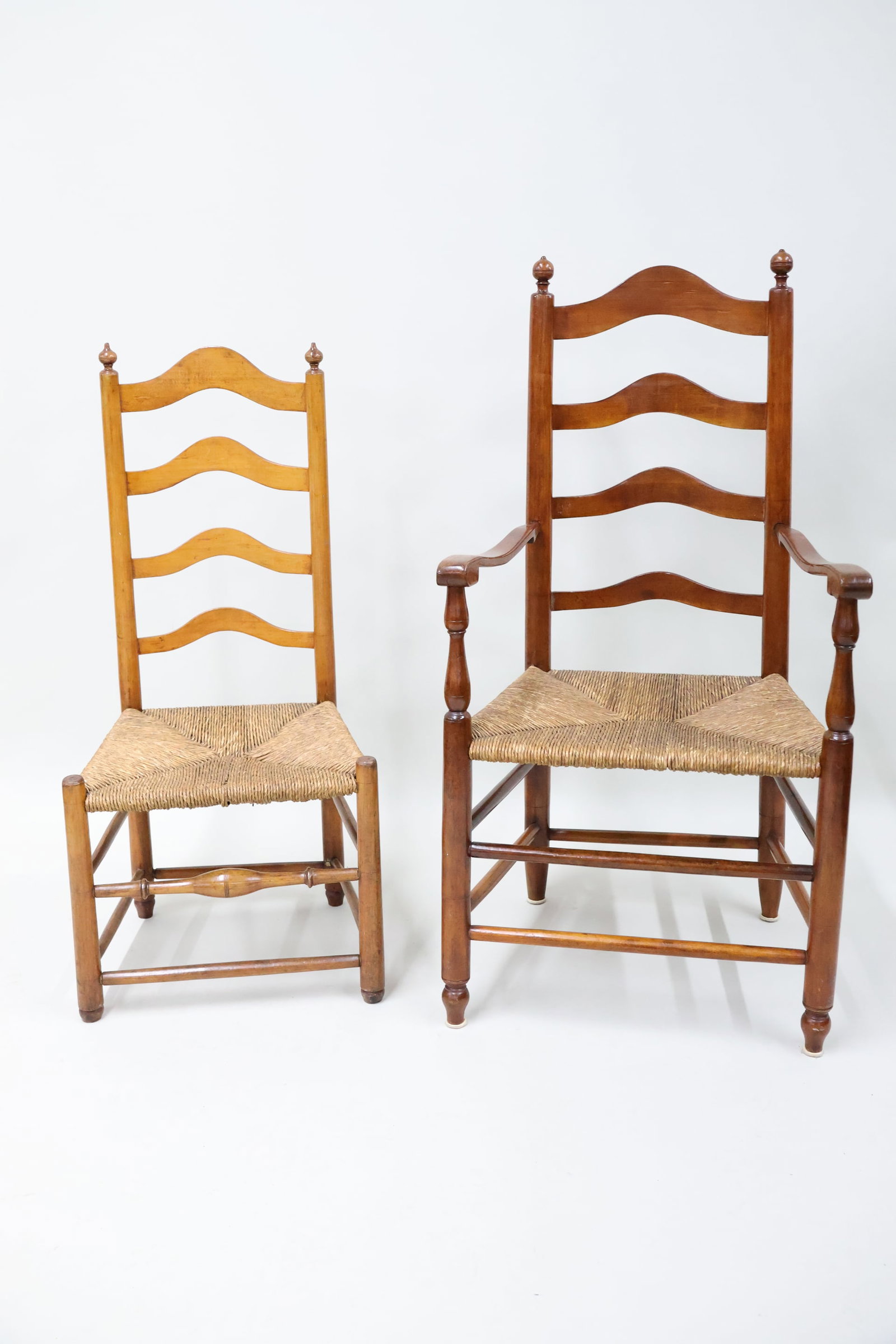Antique Rush Seat Ladder Back Armchair: Antique Rush Seat Ladder Back Armchair Antique Rush Seat Ladder Back Armchair having acorn top finials. Together with a similar ladder back side chair. Used condition, wear, worn, losses. Armchair