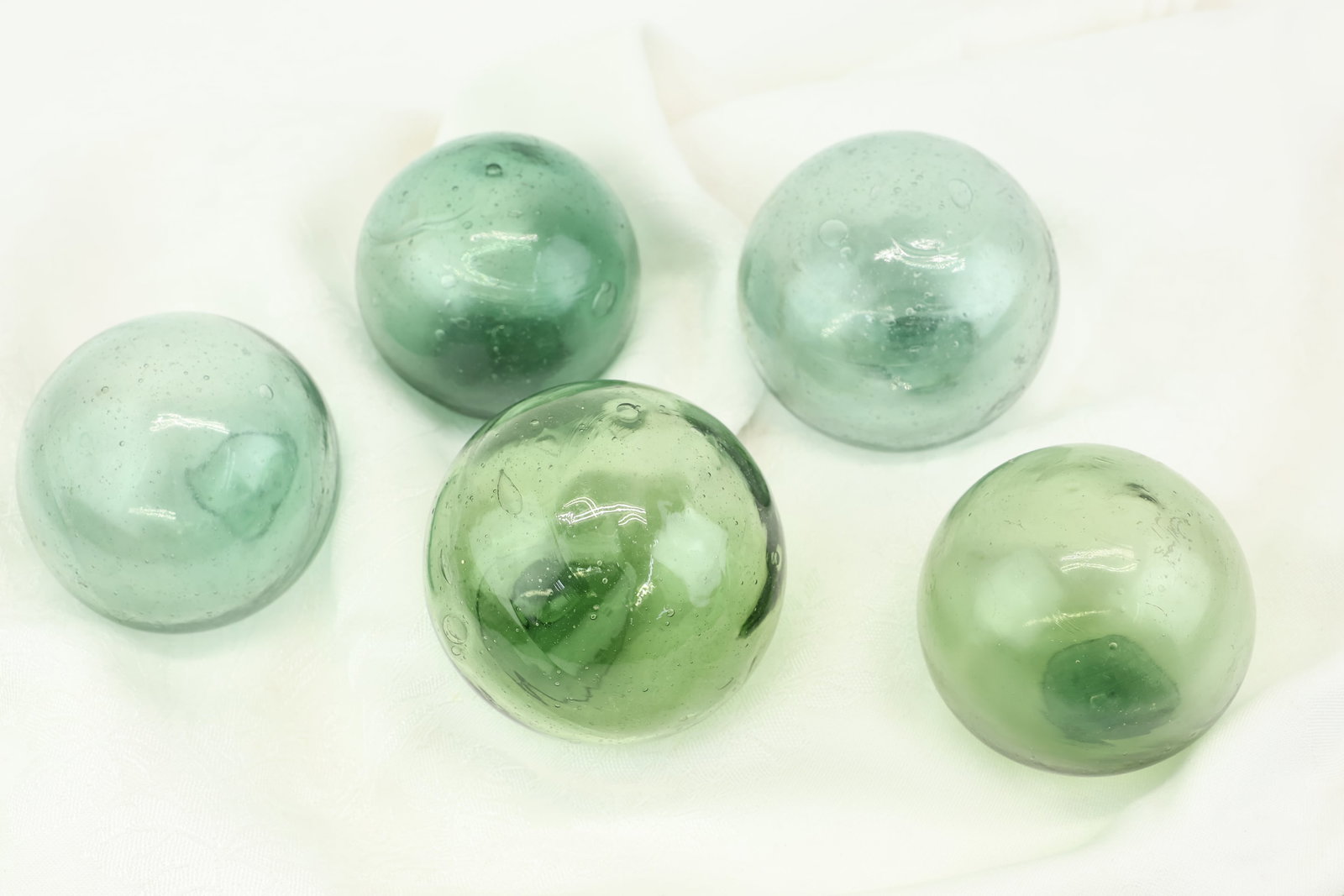 Five Green Glass Orbs: Five Green Glass Orbs Five Green Glass Orbs. Blown Glass. Used condition, wear, worn.