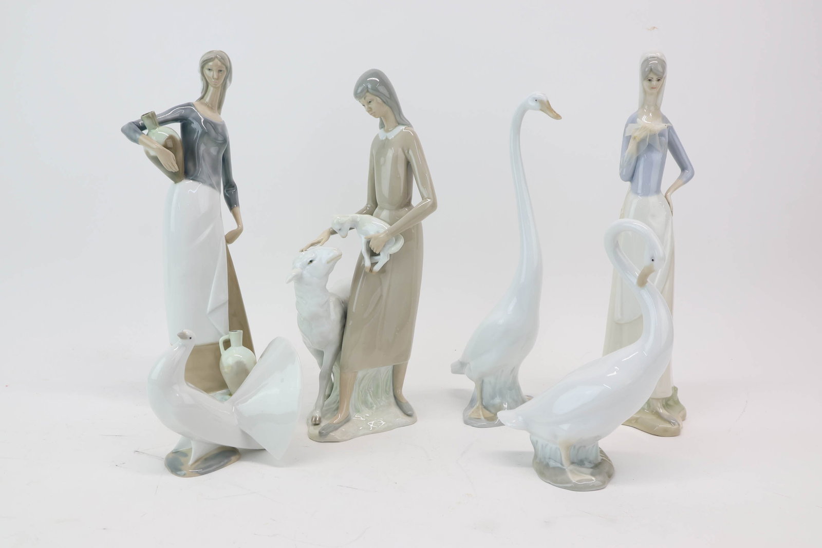Group of Assorted Lladro Figurines: Group of Assorted Lladro Figurines Group of Assorted Lladro Figurines. Comprising Nao titled The Jug Carrier may have repair to bottom jug, Peasant Girl with Sheep and Lamb, Long neck Swan, Swan with