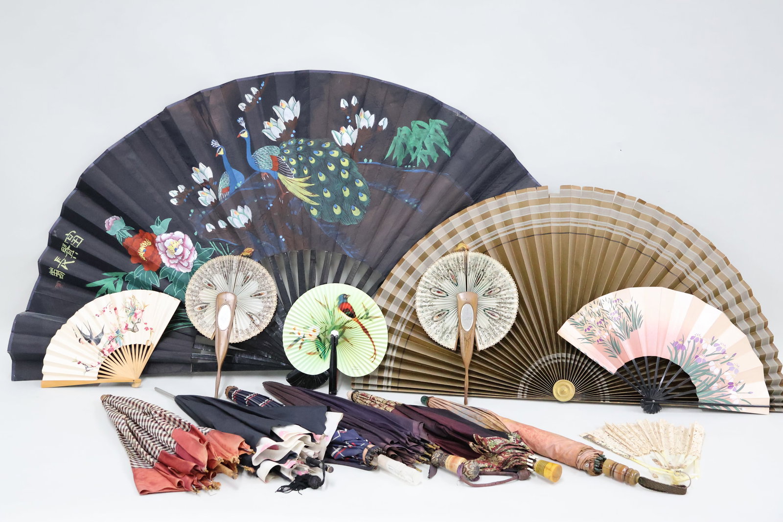 Group of Assorted Vintage Umbrellas and Fans: Group of Assorted Vintage Umbrellas and Fans Group of Assorted Vintage Umbrellas and Fans. Six umbrellas in floral, plaid and solid materials each with unique handles. Cuban and Asian hand fans made