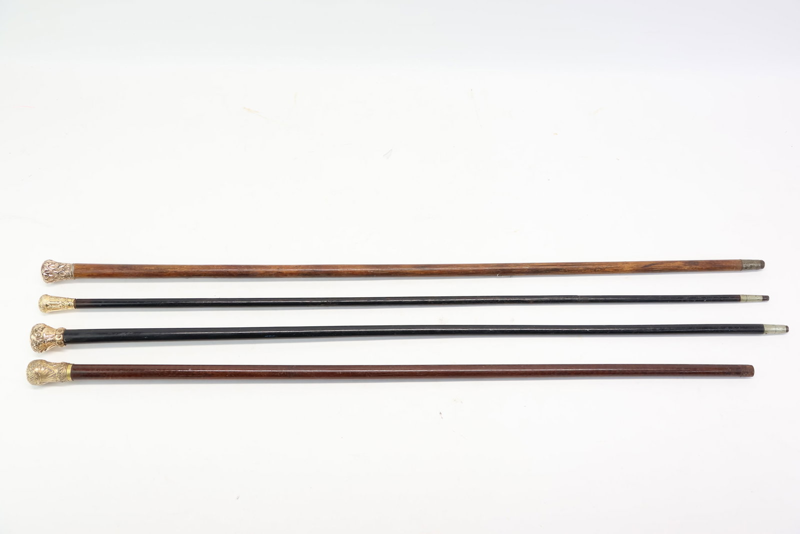 Vintage Group of 4 Gold Tone Handled Wood Canes: Vintage Group of 4 Gold Tone Handled Wood Canes Vintage Group of 4 Gold Tone Handled Wood Canes Measurements of 36" to 33 1/2" in length. One cane has monogrammed initials. Used condition, wear,