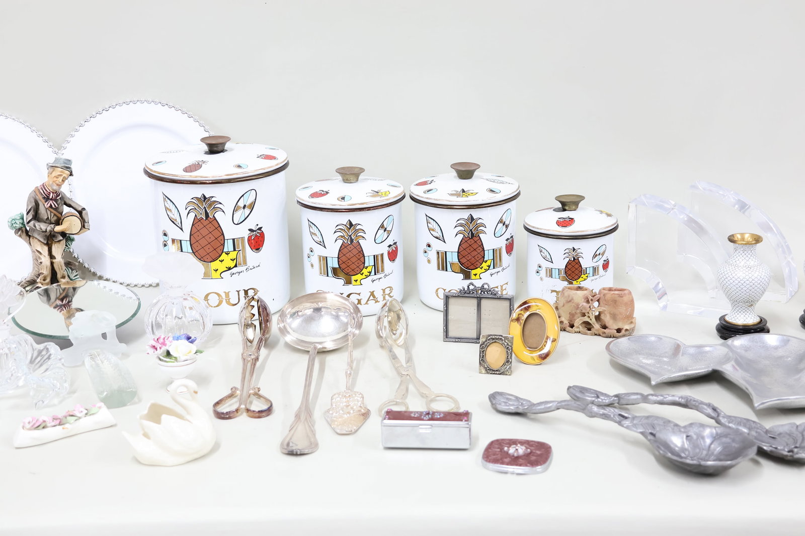 Group of Assorted Table Articles: Group of Assorted Table Articles Group of Assorted Table Articles. Including a set of Georges Briard "Ambrosia" enamelware canisters, 2 clear art glass flower figurines, clear glass perfume bottles,