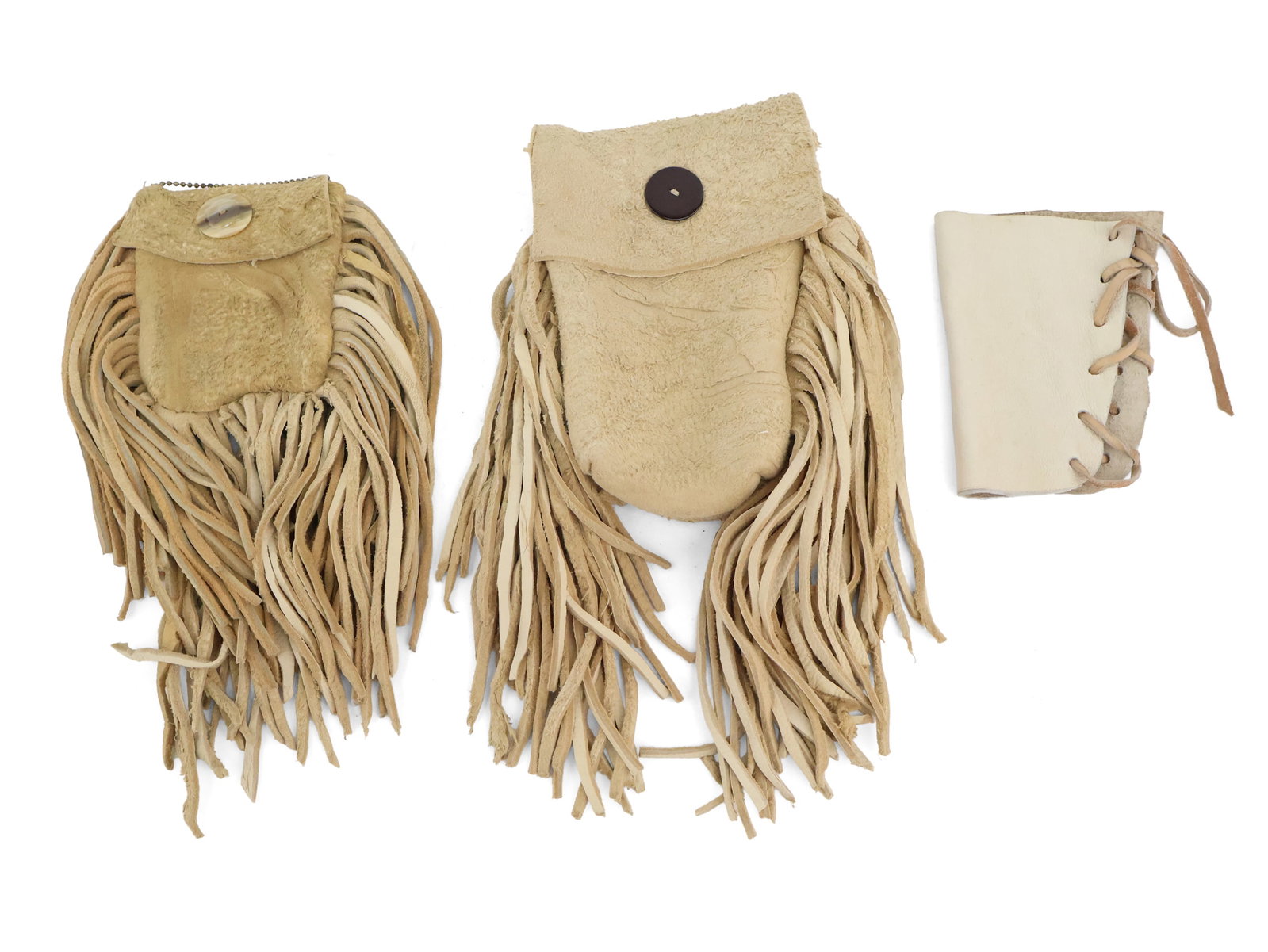 Two Fringed Leather Medicine Bags: Two Fringed Leather Medicine Bags Together with a miniature leather lace-wrapped pouch. 3 pieces Largest: 10 1/2 x 7 in. (26.7 x 17.8 cm.)