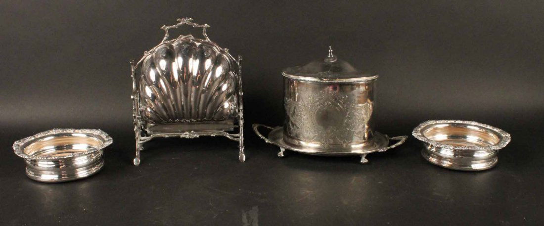 Four Silver Plated Table Articles: Comprising, a muffin warmer, a biscuit box with attached underplate, and two wine coasters. Muffin warmer, 10"h