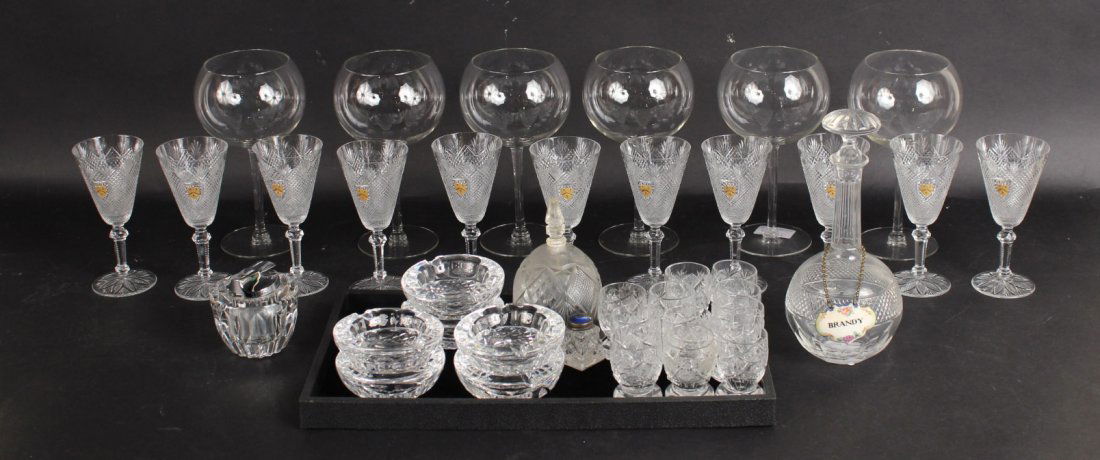 Large Group of Glass Table Articles: Comprising, six Waterford ashtrays, ten cut glass egg cups, two salts, a salt shaker, eleven sherry glasses, six wine glasses, a decanter, a bell, and a cigarette lighter. 41 pieces Ashtray: 3-1/2"dia