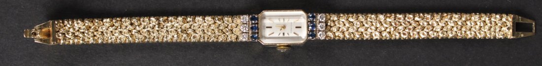Movado 14K Gold Sapphire & Diamond Wristwatch: Containing 6 round prong set diamonds, total weight approx. .42carats, and 6 round prong set sapphires, total weight .30carats, gross weight approx. 17.60dwts. 6-1/4"l