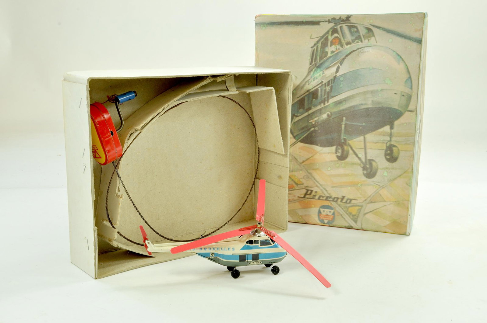 Arnold Piccolo Remote Control Helicopter, comprising: Arnold Piccolo Remote Control Helicopter, comprising Sabina Belgian World Airlines` helicopter with plastic propellers and wheels (length 15cm) on wire with tinplate hand-held unit. Looks well preserv