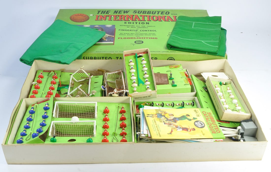 A collection of playworn Subbuteo comprising International Box and assorted contents as shown.: A collection of playworn Subbuteo comprising International Box and assorted contents as shown. Several teams and other figures and accessories. Some shirt number graffiti to most players. As shown.