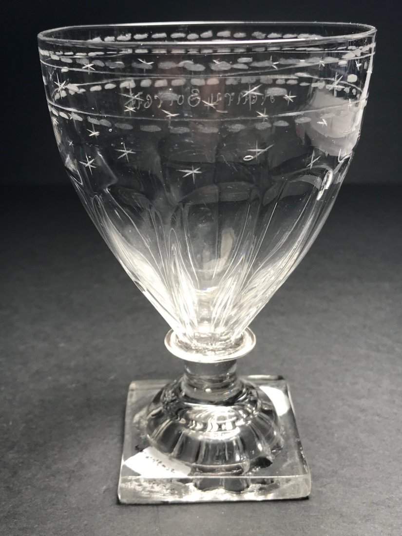 ENGRAVED PANELED RUMMER WITH LEMON SQUEEZER BASE: 5”h., Colorless, lead glass, rummer form with fluted panels around base, engraved "Henry Sorell" with stars and dashes, applied wafer and pedestal with square “lemon squeezer” base, pontil scar;
