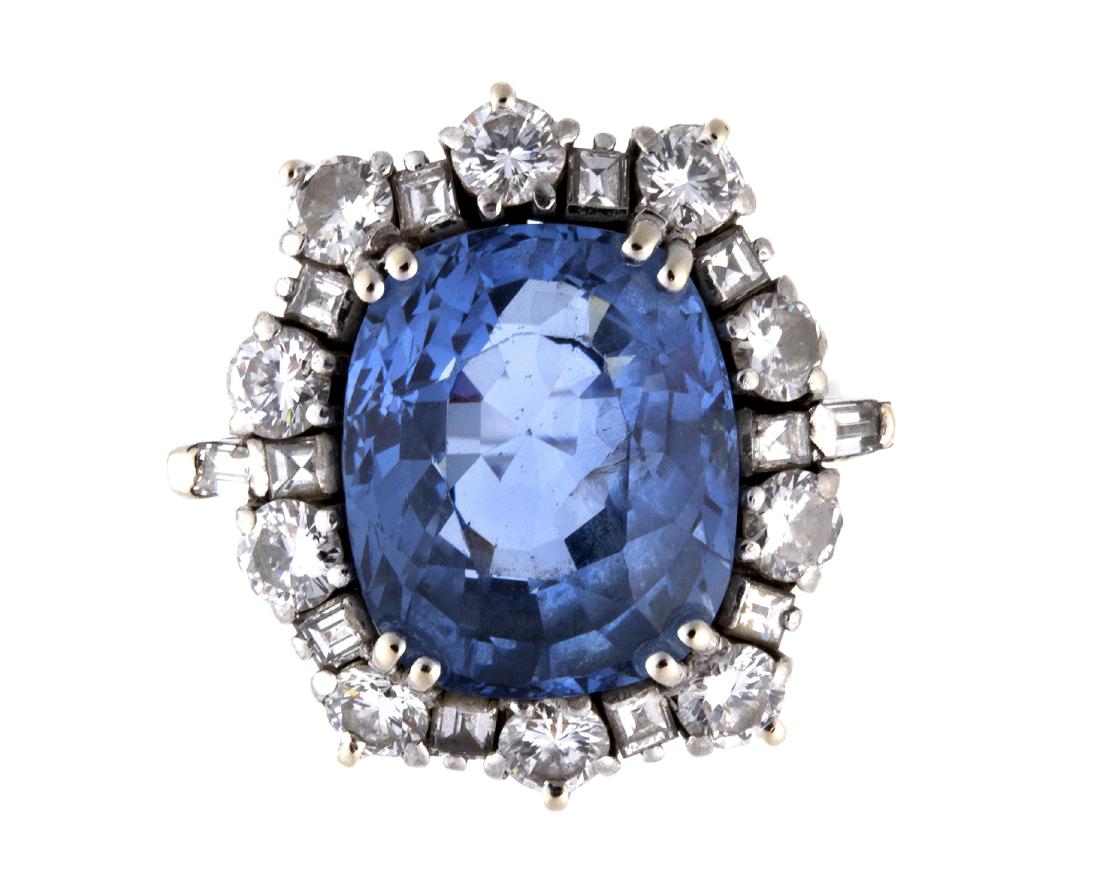 SAPPHIRE AND DIAMOND GOLD COCKTAIL RING - 80S: SAPPHIRE AND DIAMOND GOLD COCKTAIL RING - 80S Realized in white gold, set with rectangular shape with curved corner sapphire weighing 13.00 ct, surrounded by ten round shaped brilliant cut diamond VVS