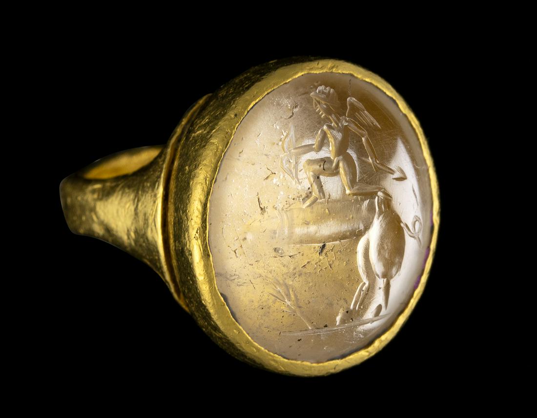 A POSTCLASSICAL ROCK CRYSTAL INTAGLIO SET IN A GOLD RING. EROS RIDING A PHALLUS. (1 of 3)