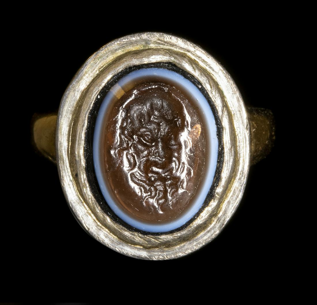 A GLASS IMPRESSION SET IN A GOLD RING. MASK OF A FAUN. (1 of 4)