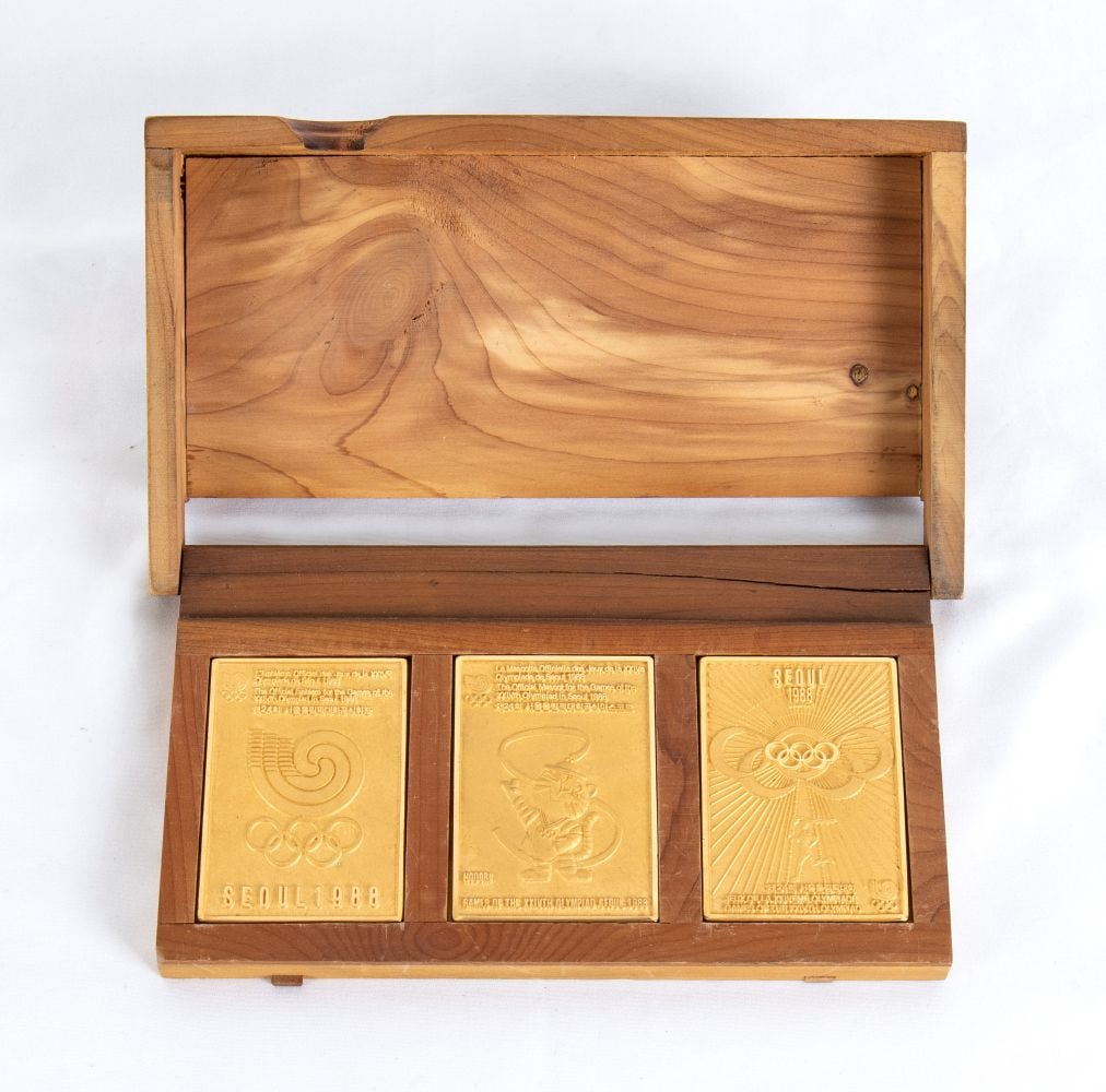 Olympics, SEOUL 1988 Gold Plated plaque set: Limited edition, set of 3 commemorative plaques of the 1988 Seoul Olympics. Depicted the official mascot, the symbol of the Olympics, the poster. In original wooden box. Measurements of each plate app