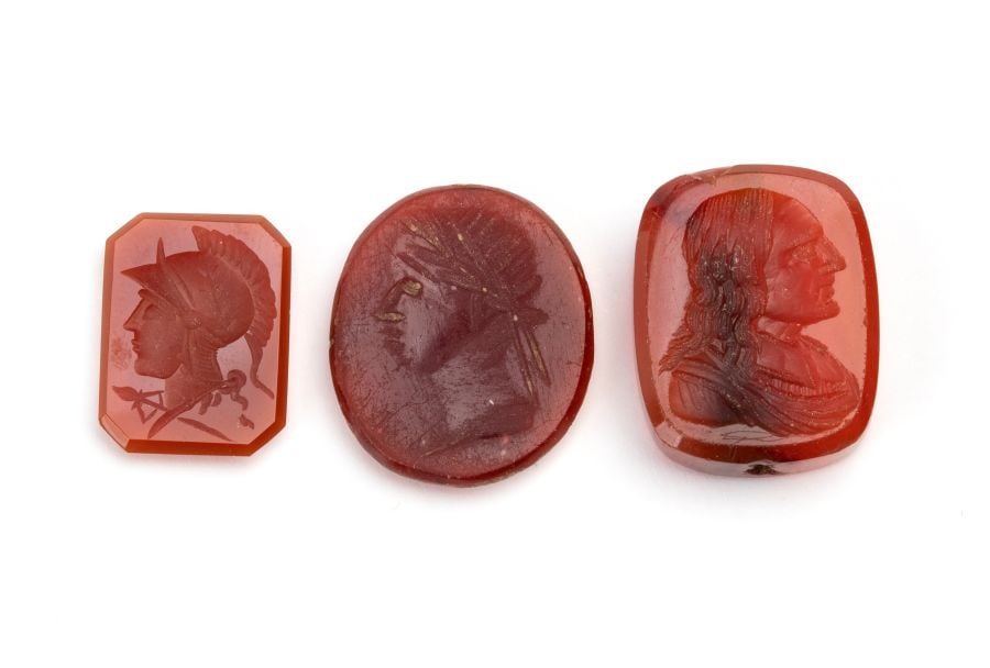 Lot of 3 carnelian carvings: Various subjects inspired by classical models: a profile of a warrior; a profile of a laureate and a profile of a male figure.Dimensions: min. 16x12x3.3 mm. - max. 20x16x5.5 mm. Item condition grading