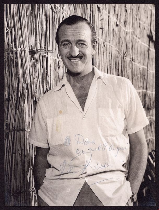 NIVEN, David - fotografia autografata: James David Graham Niven (London, March 1, 1910 ? Ch?teau-d'?x, July 29, 1983) - Photograph on matte paper, black and white, with original dedication and autograph in blue ink. In good condition, meas