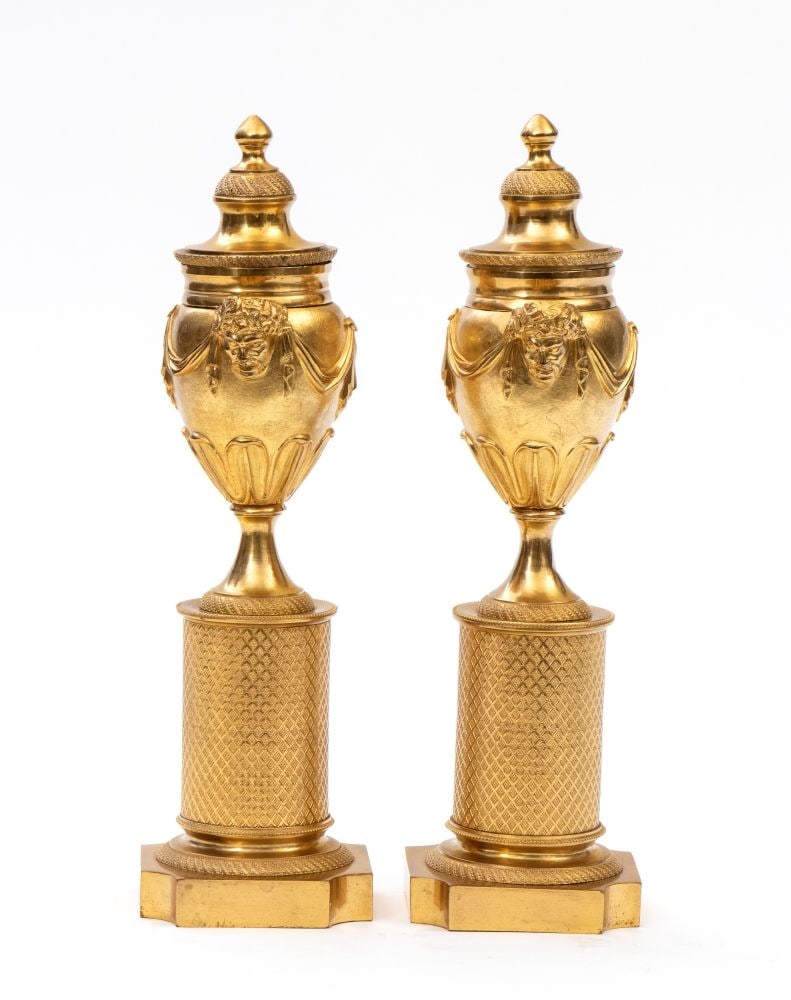 A pair of gilt bronze candlesticks from the Louis XVI period France, 18th century: A pair of gilt bronze candlesticks from the Louis XVI period - France, 18th centuryHeight x diameter: 27 x 8 cm.urn-shaped, decorated with handles shaped like faces and draped with garlands, placed on