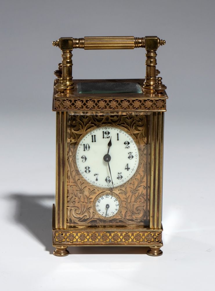 Travel clock - France, XIX secolo: Travel clock - France, XIX secoloHeight x width x depth: 16 x 8 x 6.5 cmGilded brass travel carriage clock, featuring a fluted column design and a flip-up top handle. White enamel dial with Arabic num