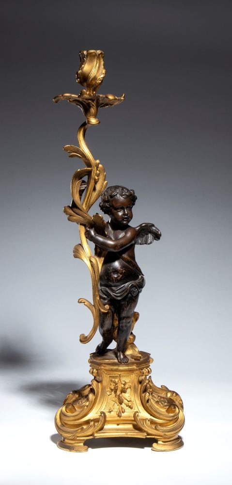 Candleholder shaped like a winged Cupid - France, 19th century: Candleholder shaped like a winged Cupid - France, 19th centuryHeight x width x depth: 56 x 20 x 26 cma refined candlestick in gilded and patinated bronze, featuring a putto in the round who, in a dyna
