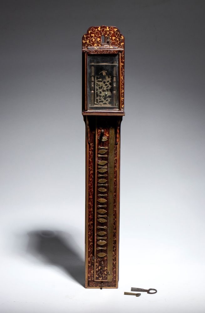 Shaku-Dokey Watch - Japan, 19th century: Shaku-Dokey Watch - Japan, 19th centuryHeight x width x depth: 51 x 8.5 x 8 cmThe upper section, protected by a glass case, features finely openwork brass decorations that offer a glimpse of the mecha