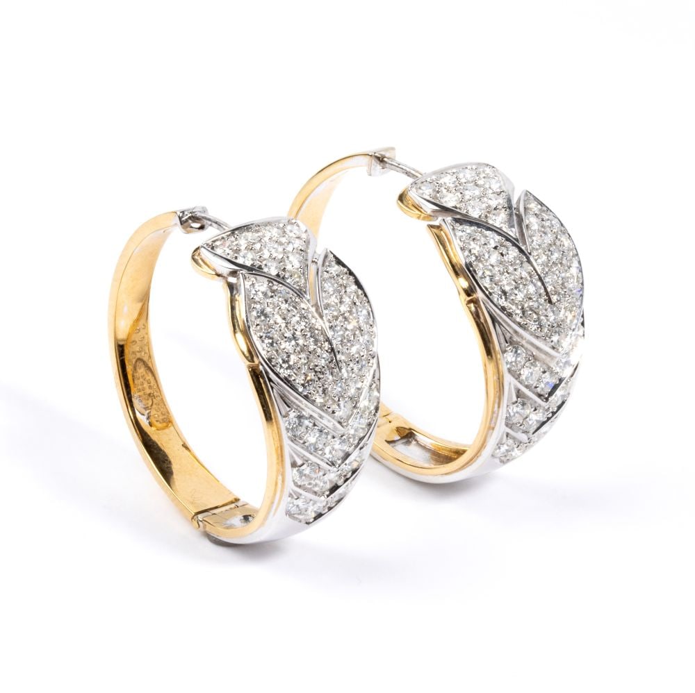 Diamond gold hoop pair of earrings: Diamond gold hoop pair of earrings white and yellow gold, featuring a floral motif in pave set round brilliant-cut diamonds estimated to weigh a total of approx. 3.80 ct, colour G-H, clarity VS-SI. Ha