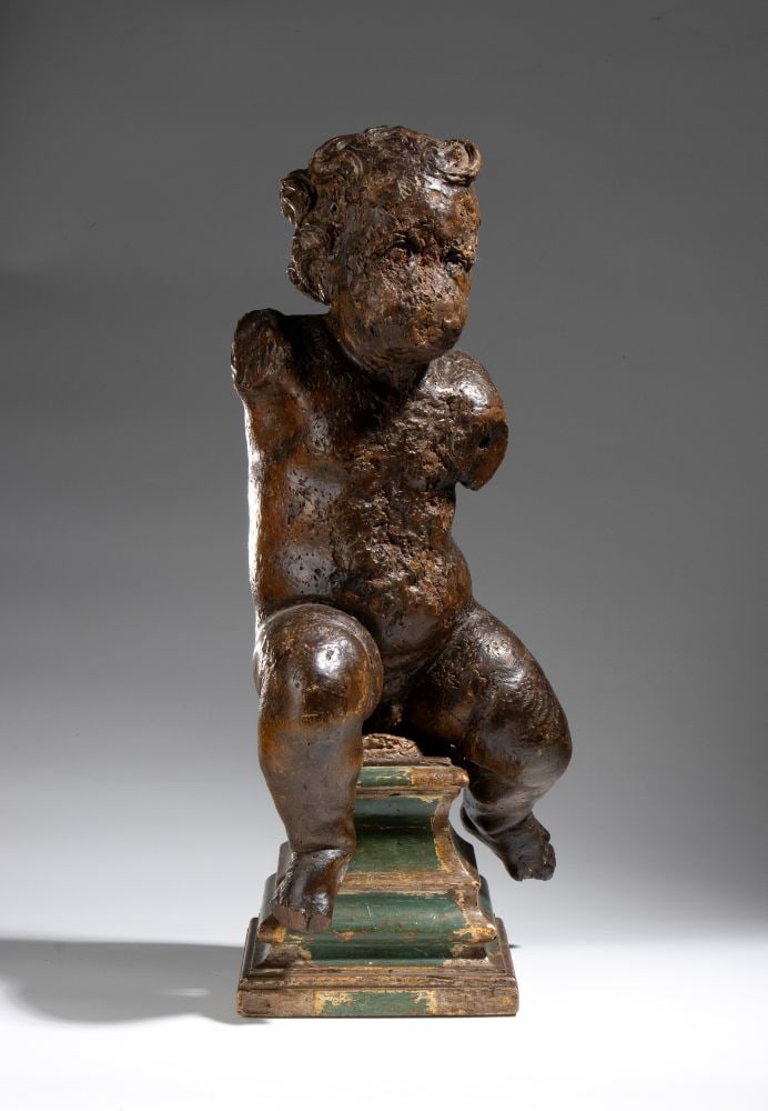 Wooden putto: Wooden puttoHeight x width x depth: 62 x 25 x 29 cm18th centuryA twisted figure seated on a molded base with green steps, likely part of a larger decorative arrangement.Item condition grading: ****