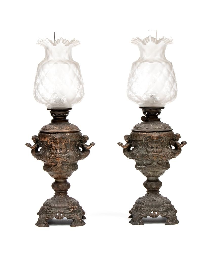 Pair of embossed metal oil lamps: Pair of embossed metal oil lampsHeight x width x depth: 65 x 24 x 18 cm20th centuryrichly decorated with eclectic motifs, including masks, scrollwork, and winged figures on the sides. Light fixtures