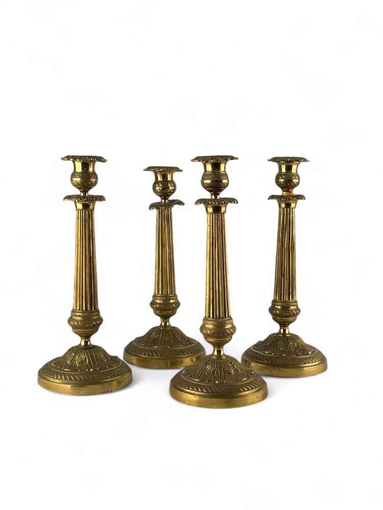 Lot of four French brass candlesticks: Lot of four French brass candlesticks Height x diameter: 28 x 12 cmEarly 20th centurycircular foot decorated with floral motifs, tapered stem and leafy coils.Item condition grading: **** good.The lot 