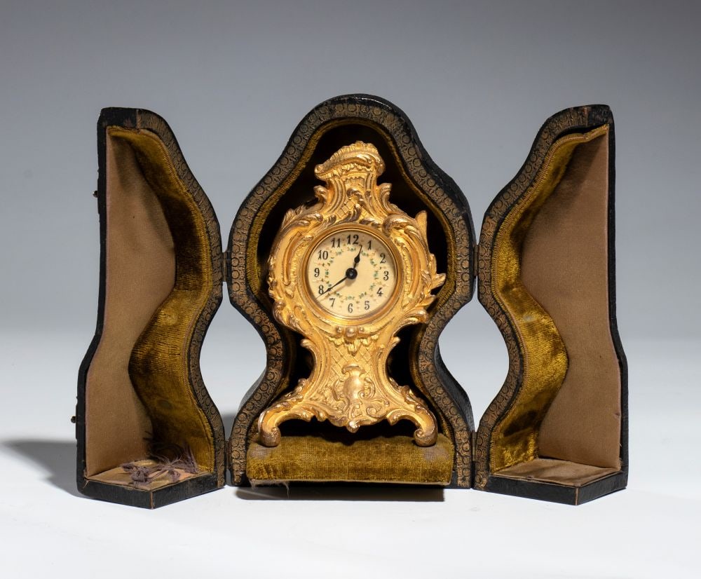 Louis XV-style travel clock - France, 19th century: Height x width x depth: 13 x 7.5 x 6 cm. Case dimensions: 16.5 x 10 x 8 cma gilded bronze case, richly decorated with scrolls, foliage, and asymmetrical motifs typical of the Louis XV style. Original 