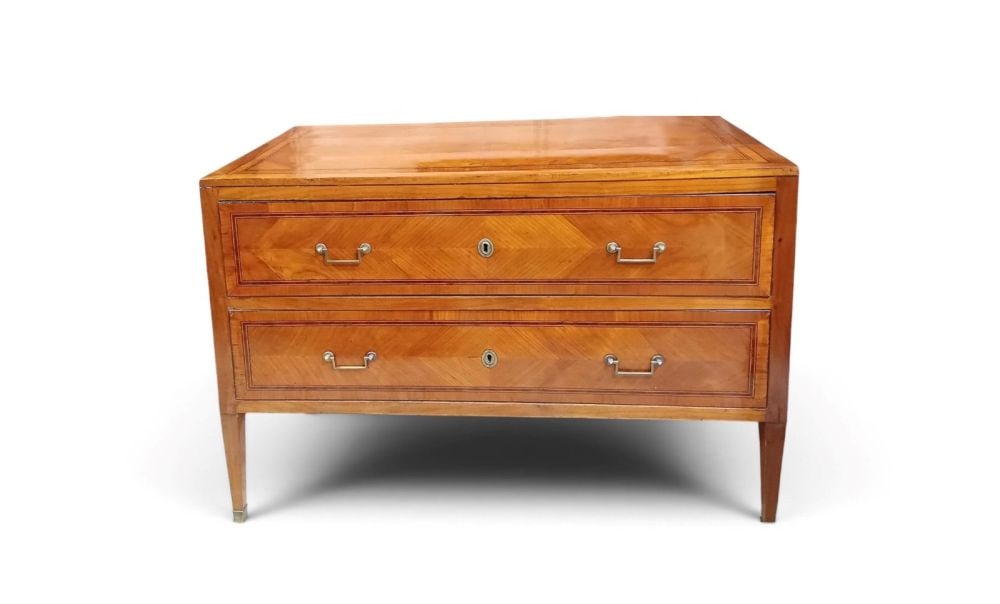 Louis XVI-style cherry wood dresser - Italy, 18th century: Height x width x depth: 130 x 65 x 92 cmveneered with a geometric herringbone pattern, two drawers, non-period handles.This lot is currently in storage with the owner.To view it in person, please cont