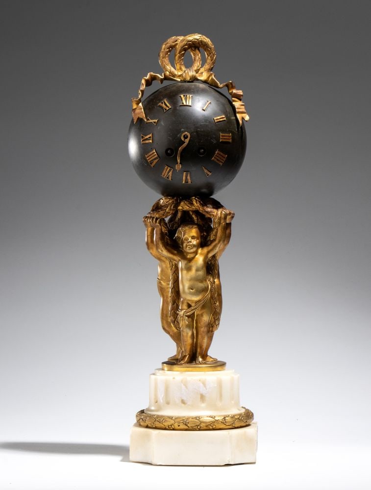 ALFRED DAUBRÉE “Pendule au Globe” table clock in gilded bronze, Louis XVI style -: Height x diameter: 43 x 13 cm the spherical dial is surmounted by a gilded bronze band that forms a knot in two rings of intertwined laurel leaves, a decorative motif typical of the neoclassical reper