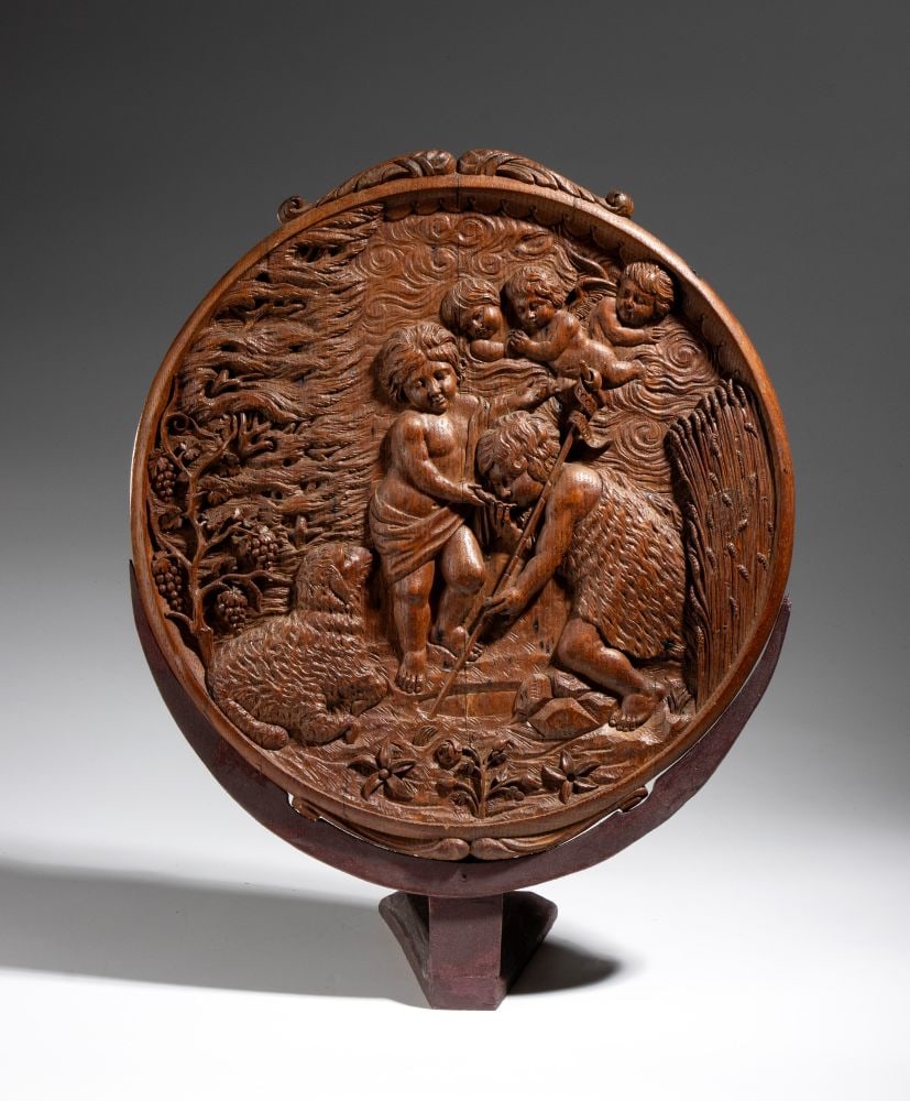 Round oak panel depicting the infant Jesus with St. John the Baptist and cherubs - Northern Europe,: Height x width x depth: 43 x 33 x 16 cmThe scene depicts the Infant Jesus and the Young Saint John at the center. Above, among the clouds, three heads of winged cherubs appear, in accordance with cust