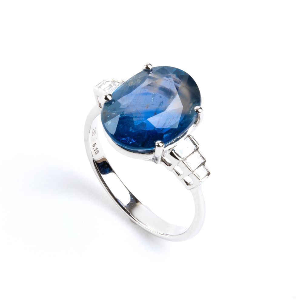 Blue sapphire diamond gold ring: 18k white gold, set with an oval shaped sapphire flanked by baguette-cut diamonds.N. 06 rectangular shaped diamonds, estimated to weigh a total of approx. 0.30 ct, F-G colour, VVS clarity and n. 01 ov