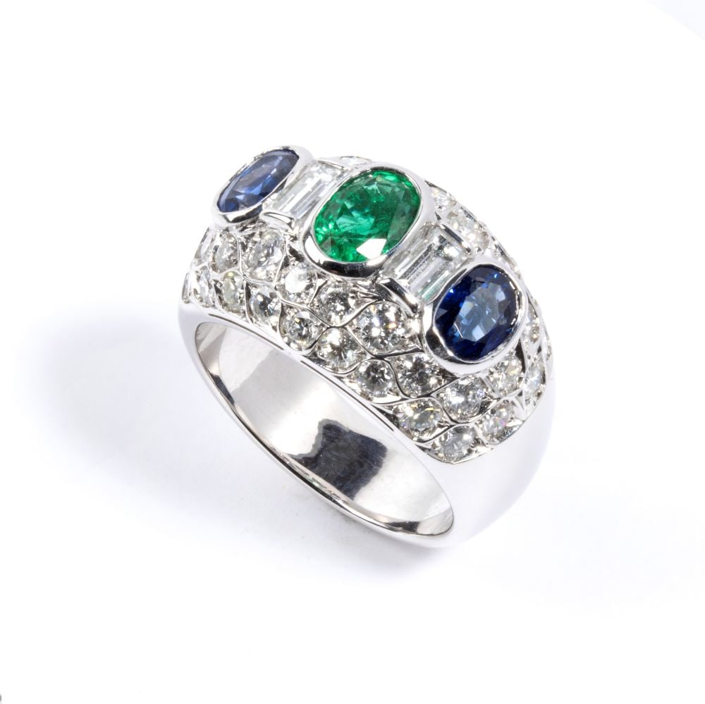 Emerald sapphires diamonds gold ring: 18k white gold, set with a couple of blue sapphires and one oval emerald surrounded by diamonds. N. 40 round brilliant diamonds and n. 02 rectangular step cut diamonds, estimated to weight a total of 