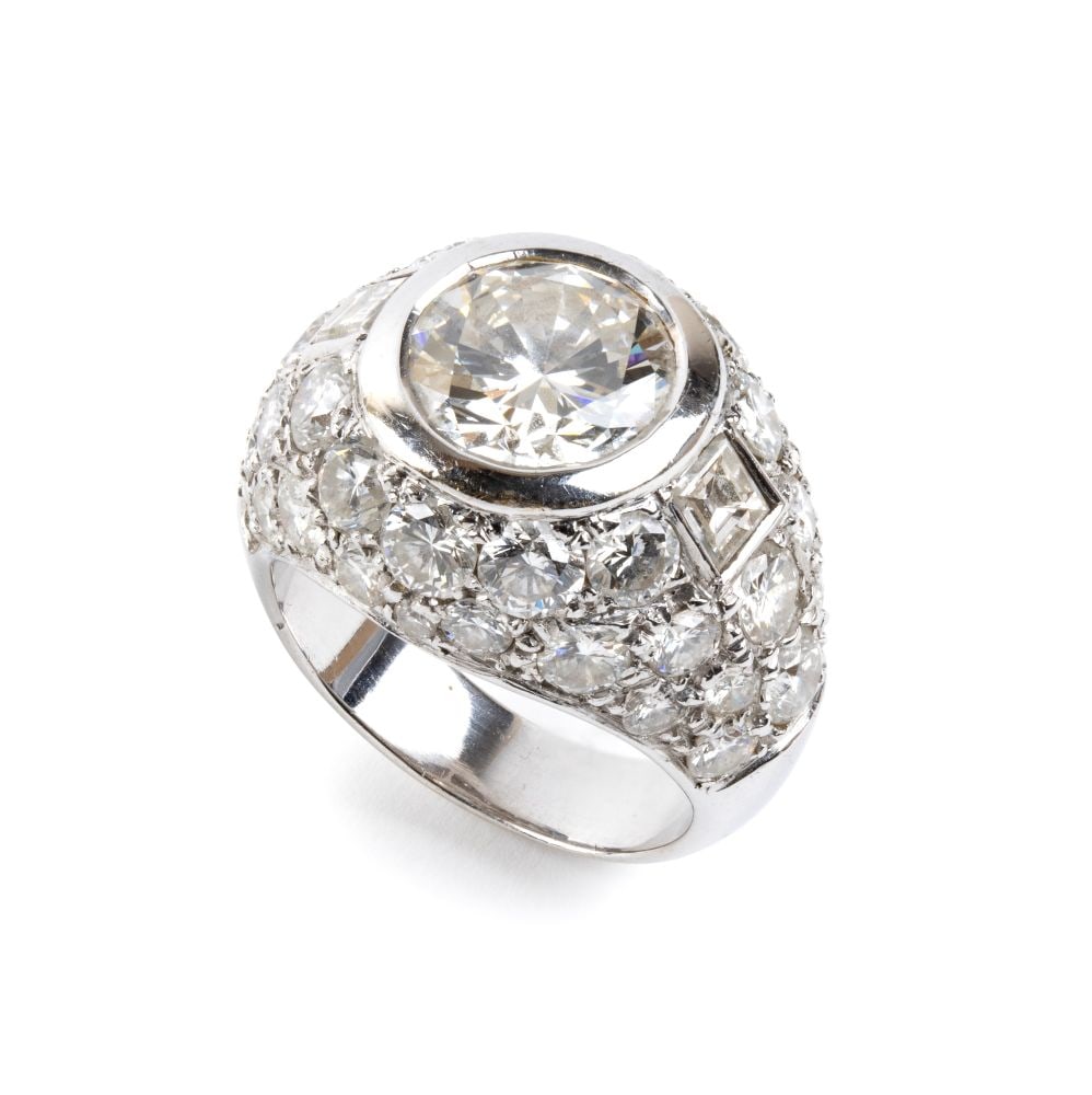 Diamond gold band ring: 18k white gold, set with a central round brilliant-cut diamond, estimated to weigh approx. 3.10 ct, colour I-J, clarity VVS, flanked by a pair of baguette-cut diamonds and surrounded by a pavé