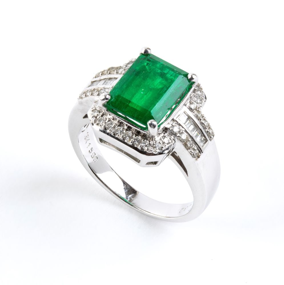 Emerald diamond gold ring: 18k white gold, set with an octagonal-shaped emerald estimated to weigh approx. 3.00 ct, surrounded by brilliant-cut and baguette-cut diamonds, estimated to have a total weight of approx. 0.49 ct, col