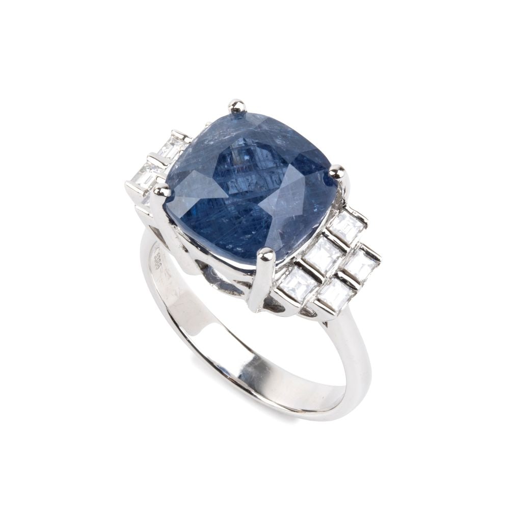 Blue sapphire diamond gold ring: 18k white gold, set with a cushion-cut sapphire estimated to weigh approx. 8.07 ct, flanked by 10 baguette-cut diamonds estimated to weigh a total of approx. 0.70 ct, color F-G, clarity VVS-VS, as