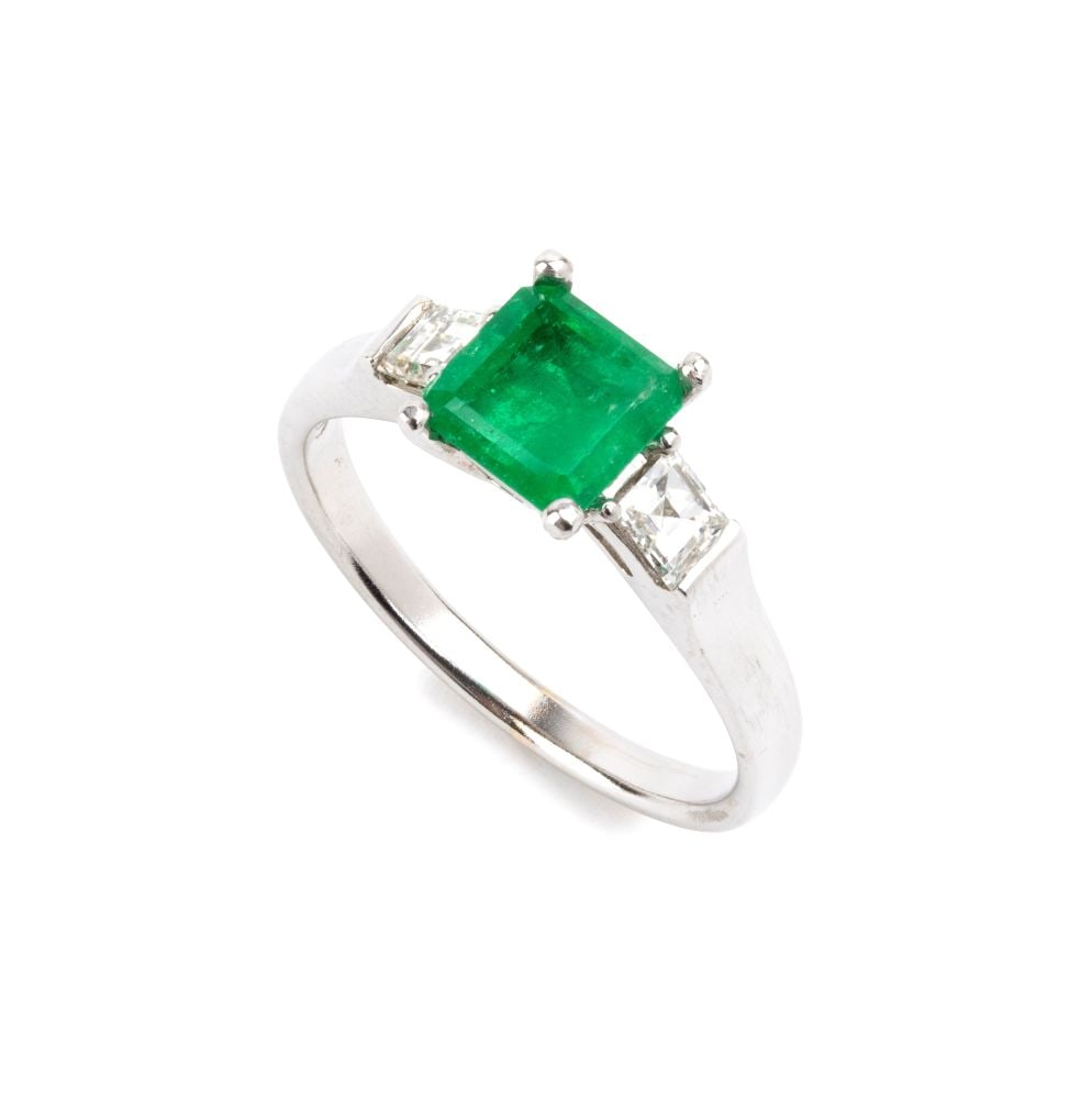 Emerald diamond gold ring: 18k white gold, set with an emerald-cut emerald, estimated to weigh approx. 0.98 ct, flanked by a pair of baguette-cut diamonds estimated to weigh a total of approx. 0.70 ct, colour G-H, clarity