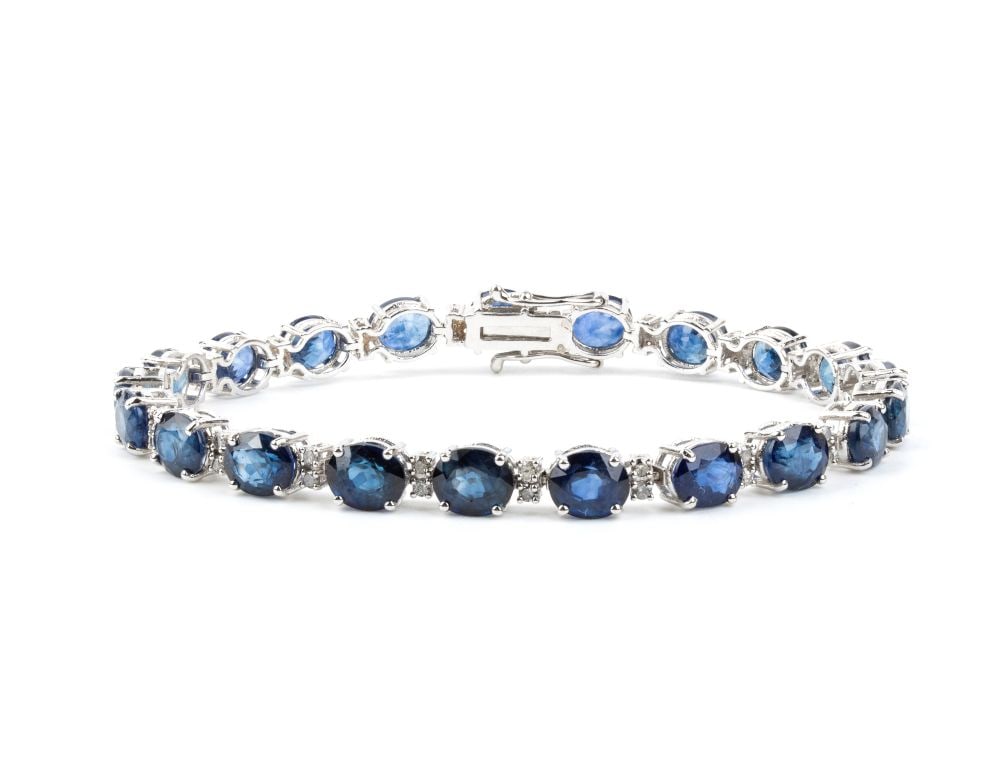 Blue sapphie diamond gold bracelet: 18k white gold, set with a row of oval sapphires estimated to weigh approx. 25.00 ct, separated by pairs of brilliant-cut diamonds estimated to weigh a total of approx 0.80 ct, color I-J, clarity