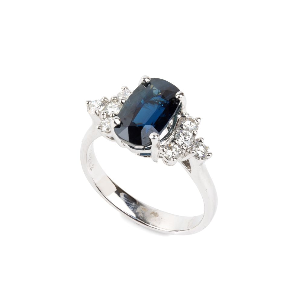Blue sapphire diamond gold ring: 18k white gold, set with one oval shaped, composite-cut sapphire, estimated weight approx. 3.28 ct, flanked by n. 06 round brilliant-cut diamonds, estimated to weigh a total of approx. 0.18 ct, G-H