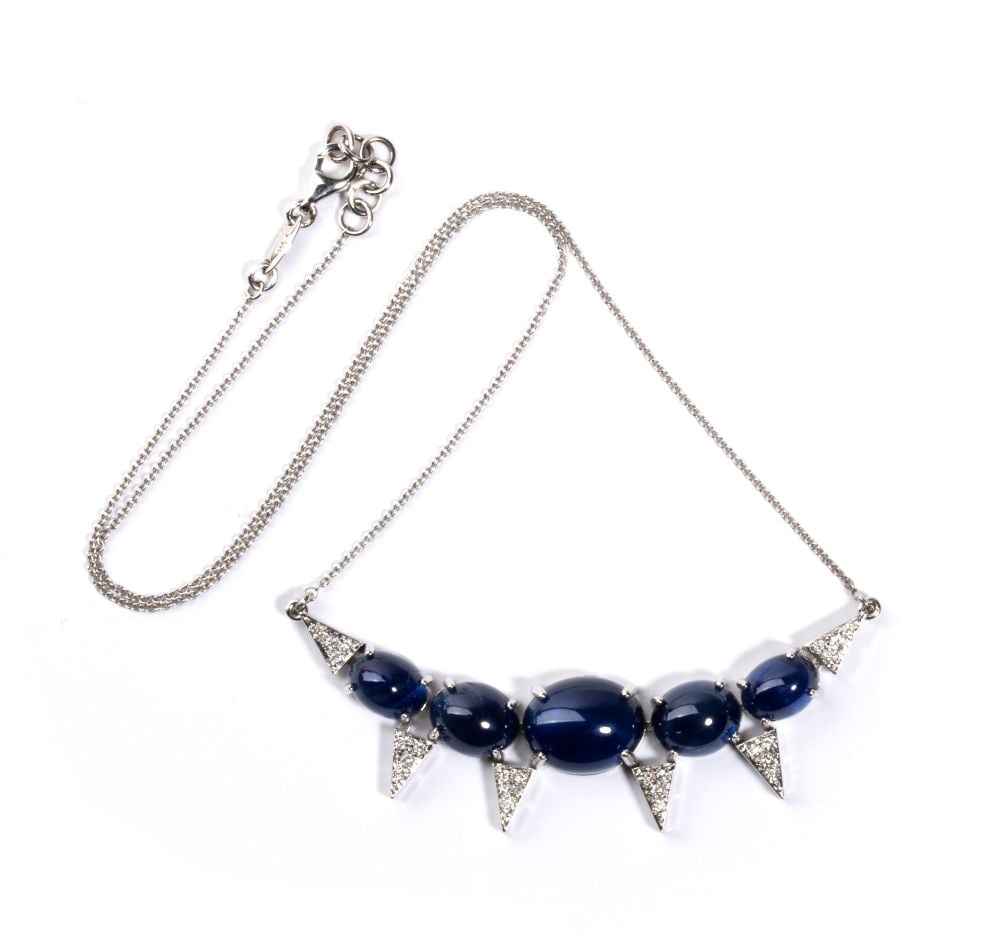 Sapphire diamond gold necklace: 18kt white gold, with a thin necklace chain with a central curved bar featuring a row of cabochon-cut blue sapphires and geometric diamond elements.N. 05 oval shaped, cabochon-cut sapphire, estimated 