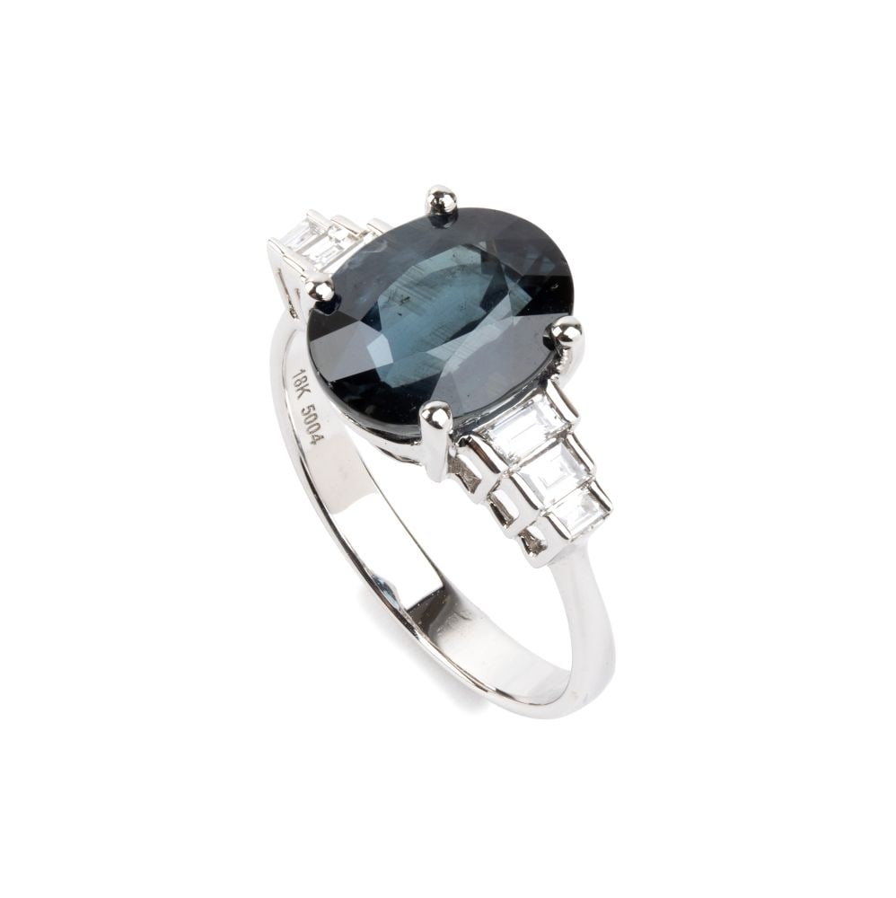 Blue sapphire diamondgold ring: 18k white gold, set with an oval-shaped sapphire, composite cut, estimated to weigh approx. 4.14 ct, flanked by baguette-cut diamonds estimated to weigh a total of approx. 0.30 ct, colour F-G,